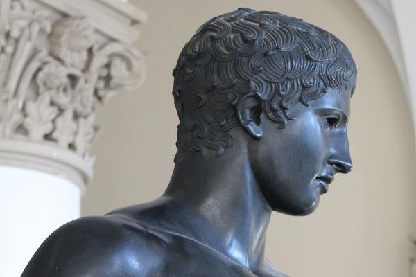 Zu sehen ist der Kopf der Bronzeskulptur „Speerträger“ aus dem Universitätshauptgebäude der LMU im Profil.